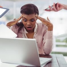 Digital composition of stressed businesswoman sitting with laptop and people holding electronic devices around her